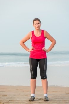 Girl in sportswear before exercise on the beach