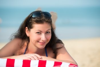 beautiful young woman lying on a lounger near the sea