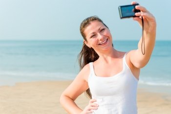 girl on a background of the sea with a small camera