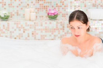 Brunette relaxing in the bath with foam