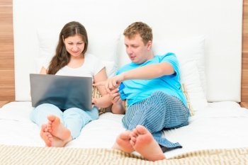 young couple in pajamas shopping online