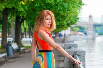 bright beautiful woman near the river in the city