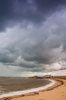Art toned image of fishing shacks with stormy skies. Crimea.