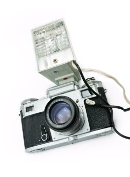 Classic film rangefinder camera with flash isolated on a white background