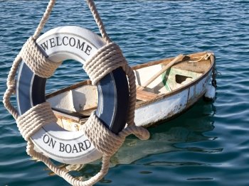 old wooden boat on the sea and safe belt with sign welcome on board