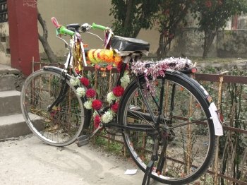 decorative old  painted bicycle with basket of colorful flower  fot puja in Rishikesh India           