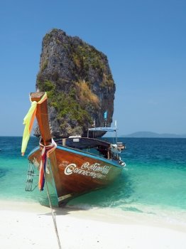 KRABI, THAILAND - FEBRUARY 15, 2015: Traditional Thai wooden longtail boat waits on the shore of Bamboo Island for passengers on a day trip from Phi Phi Island.
