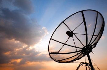 Big telecommunication satellite dish over sunset sky