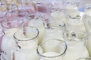 many glass jugs with milk and yogurt for breakfast
