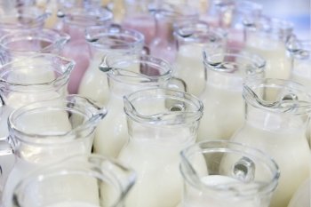 many glass jugs with milk and yogurt for breakfast