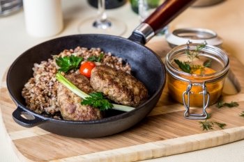 Restourant serving dish - cutlet with buckwheat on wooden board