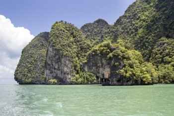 The green waters surrounding the limestone cliffs of Koh Phanak  in Phang Nga Bay, Thailand