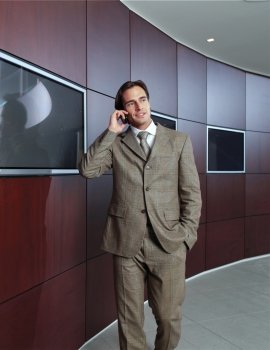 Businessman talking on mobile phone in office lobby 