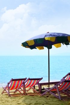 Chairs and umbrella at a sandy beach
