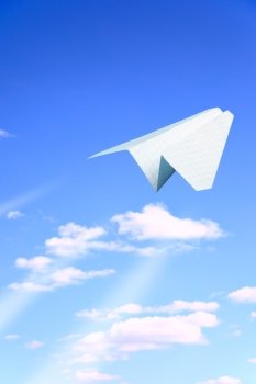 Paper plane flying. Sky and clouds in the background 