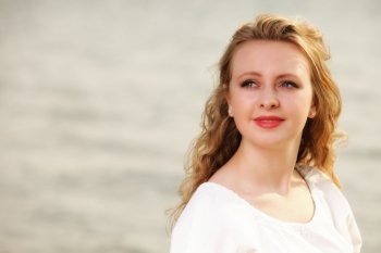 Portrait young woman smiling blonde girl on beach wind in hair , summer holiday