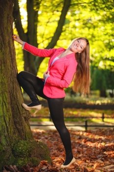 Fall season. Full length of happy girl young woman in pink in autumnal park forest. Outdoor.