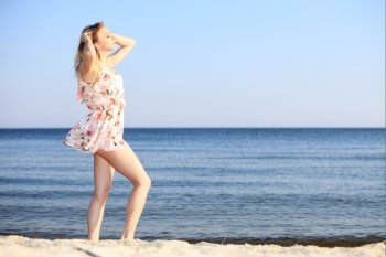 Full length woman in summer dress at the sandy beach. Vacation, summertime concept.