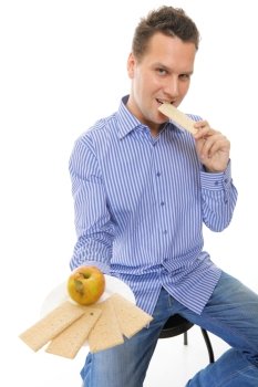 Positive man eating healthy in her diet, having a crispbread and apple studio shot isolated on white background. Healthcare and nutrition concept