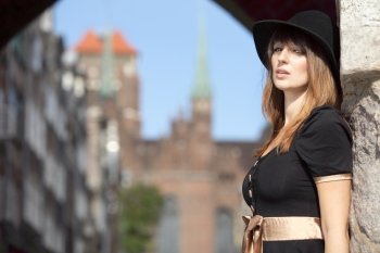 Portrait pretty retro woman in black hat outdoors in european city  old town Gdansk Danzig