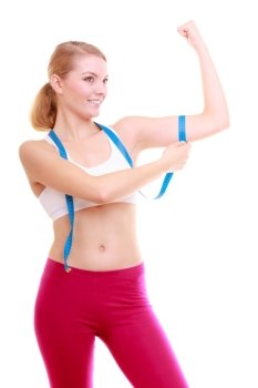 Power and energy. Health care and healthy active lifestyle. Young fitness woman fit girl with measure tape measuring her biceps isolated on white