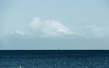 cloudy sky above a blue surface of the sea. Seascape