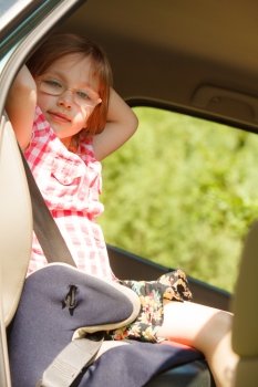 Road transportation and safety. Little girl child kid sitting in car seat and preparing to trip travel.
