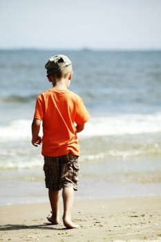 child little boy on the beach with sea on background