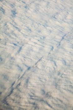 Blue white cloudy sky. View from window of airplane flying in clouds. Skyscape cloudscape. Bird's eye.