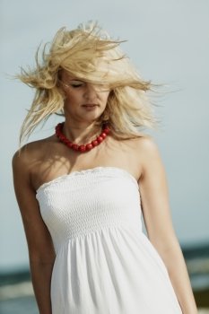 Holidays, vacation travel and freedom concept. Beautiful girl in white dress on beach. Lovely woman portrait outdoor, hair blowing on wind