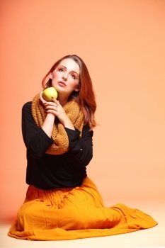 Fall. Fashion woman in autumn color girl in full length with apple long false orange eye-lashes