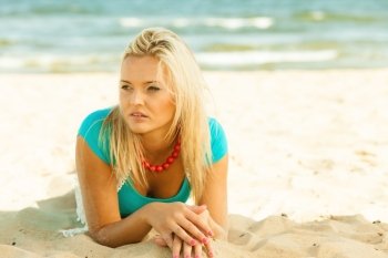 Holidays, vacation travel and freedom concept. Beautiful blonde girl laying on sandy beach, portrait