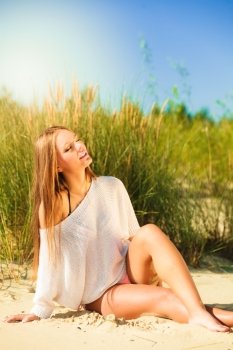 Young woman female model posing outdoor on background of dunes sky and grass