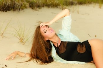 Holidays, vacation travel and freedom concept. Adorable long haired girl laying on sandy beach outdoor