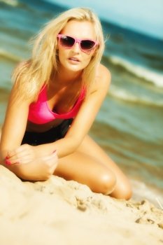 Holidays, vacation travel and freedom concept. Beautiful blonde sexy girl on beach. Young woman relaxing on the sea coast.
