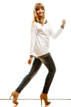 Fashion. Young blonde fashionable woman jeans pants white long-sleeved shirt. Female model posing isolated studio shot