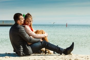 loving couple spending leisure time together at beach hugging side view