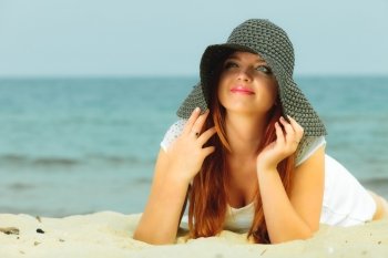 Holidays, vacation travel and freedom concept. Beautiful redhaired happy girl in hat on beach.