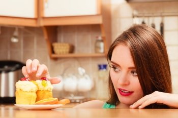 Woman eating delicious cake with sweet cream and fruits on top with finger. Appetite and gluttony concept.. Woman eating delicious sweet cake. Gluttony.