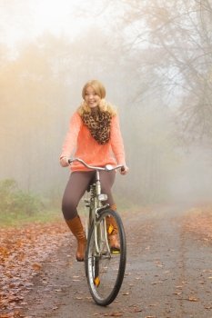Active woman riding bike in autumn park.. Active woman girl relaxing riding bike bicycle in fall autumn park. Healthy lifestyle.