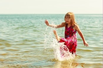 Little girl kid splashing in sea ocean water. Fun. Little girl child having fun in ocean. Kid and woman bathing splashing sea water. Summer vacation holiday relax.