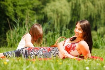 Summer children and happy family concept. Mother and daughter little girl having picnic playing in park outdoors.