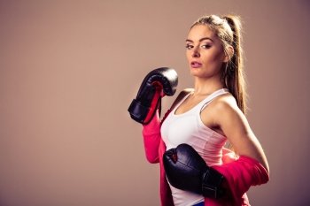 Feminist and emancipation idea. Woman in male occupation, training, boxing. Fit female fitness girl doing exercise in studio. Retro and vintage photo.