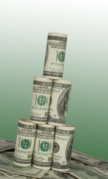 Leaning Tower of hundred dollar bills on green background