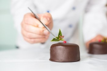 Confectioner putting the last ornament to a cake