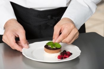 Chef decorating a homemade mousse with berries