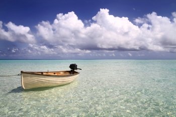 A small rowing boat drifting on an aqua blue sea at Gili Lankanfushi (formerly Soneva Gili) in the Maldives